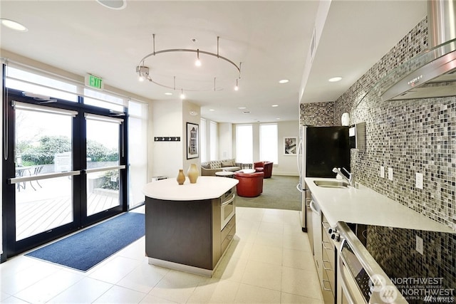 interior space featuring track lighting, tasteful backsplash, plenty of natural light, and a kitchen island