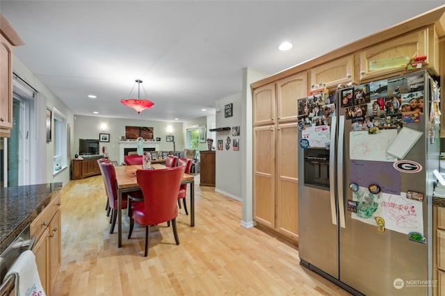 kitchen with light brown cabinetry, pendant lighting, light wood-type flooring, and stainless steel fridge with ice dispenser