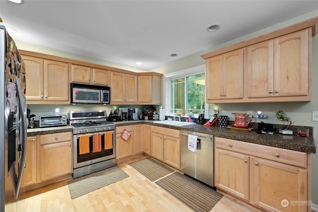 kitchen featuring sink, light brown cabinets, light hardwood / wood-style flooring, and stainless steel appliances