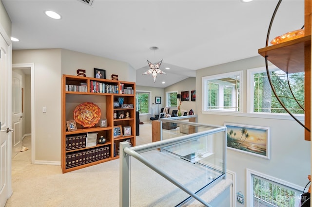 rec room with lofted ceiling, a healthy amount of sunlight, and light carpet