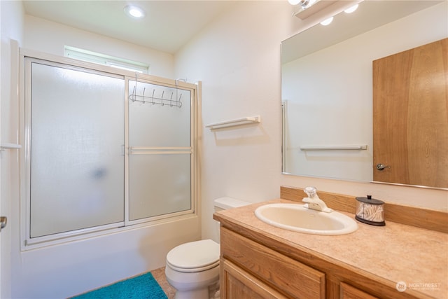 full bathroom with vanity, enclosed tub / shower combo, and toilet