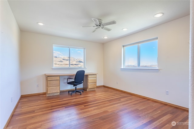 unfurnished office with ceiling fan and wood-type flooring