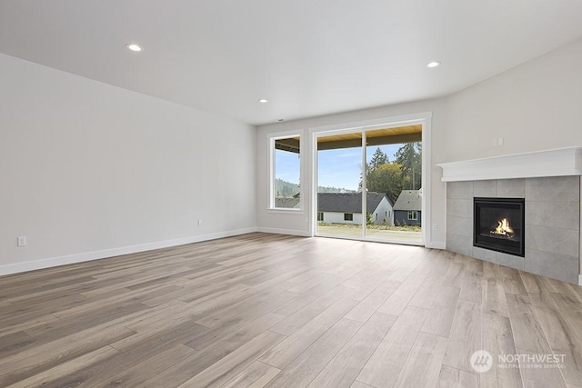 unfurnished living room with a fireplace and light hardwood / wood-style floors