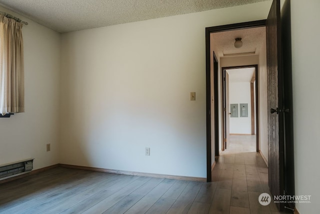 unfurnished room featuring hardwood / wood-style floors and a textured ceiling