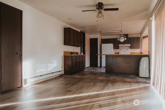 kitchen with white refrigerator, dark brown cabinetry, a baseboard radiator, hardwood / wood-style floors, and ceiling fan