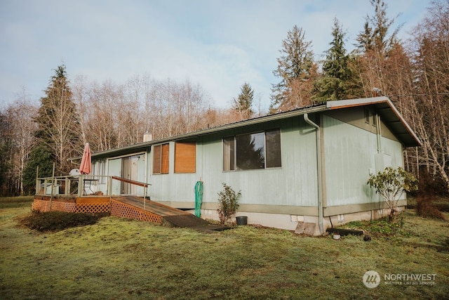 view of property exterior featuring a lawn and a deck