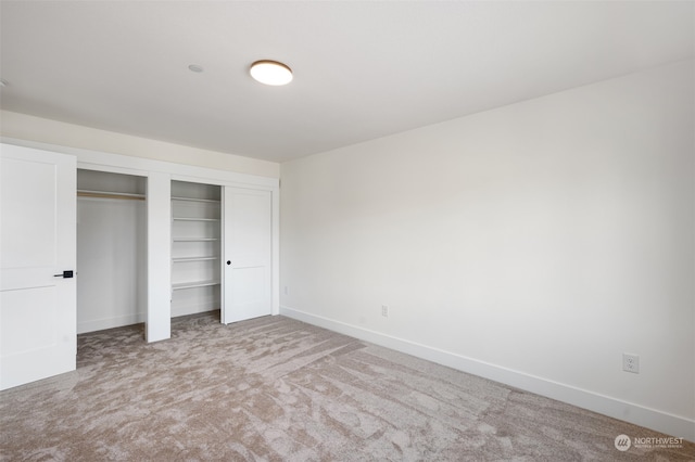 unfurnished bedroom with light carpet and a closet