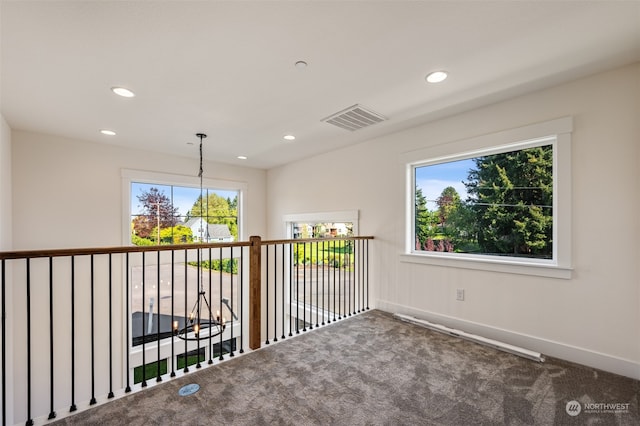 hall featuring carpet flooring and plenty of natural light