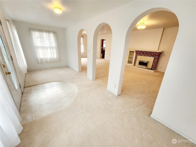 carpeted empty room with a fireplace