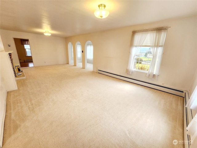 carpeted empty room featuring a baseboard heating unit