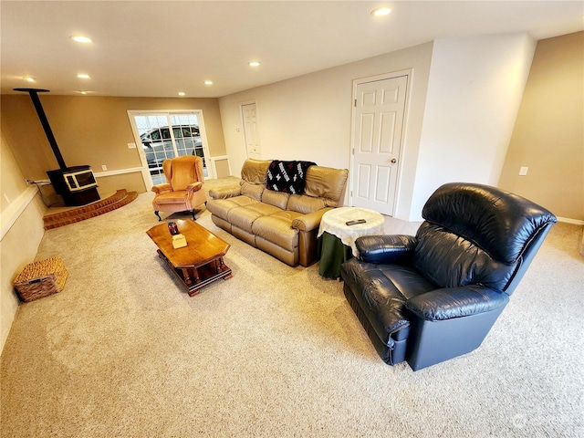 living room featuring carpet floors and a wood stove