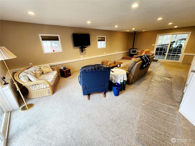 living room featuring carpet and a wood stove