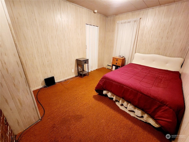 bedroom featuring a baseboard radiator, wooden walls, and carpet