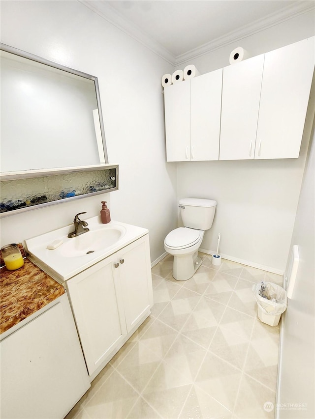 bathroom with ornamental molding, vanity, toilet, and tile patterned floors