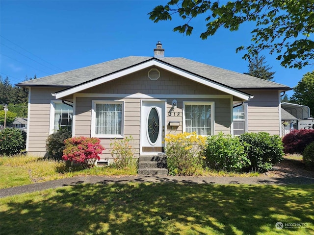 bungalow-style house featuring a front lawn