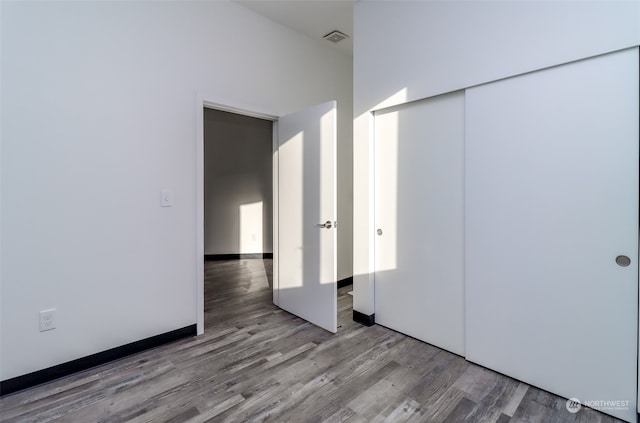 unfurnished bedroom featuring hardwood / wood-style flooring and a closet