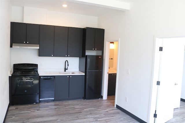 kitchen featuring sink, beamed ceiling, light wood-type flooring, and black appliances