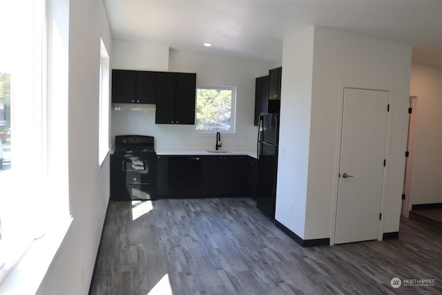 kitchen featuring sink, black appliances, lofted ceiling, and hardwood / wood-style flooring