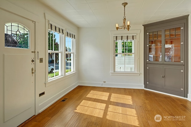 doorway with a chandelier and hardwood / wood-style flooring