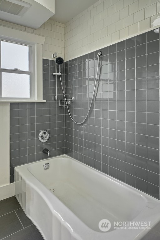 bathroom with tiled shower / bath and tile patterned floors