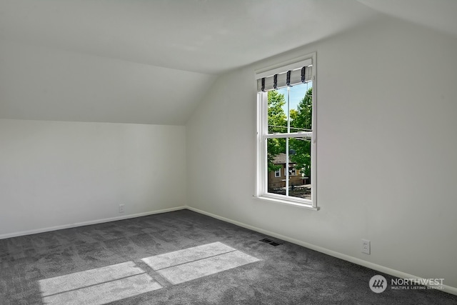 bonus room featuring dark colored carpet and vaulted ceiling