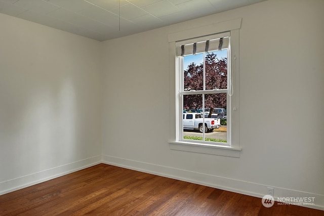 spare room featuring wood-type flooring and a healthy amount of sunlight