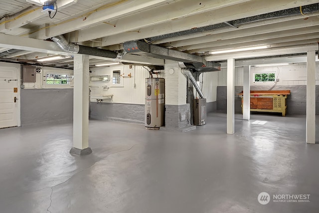 basement featuring heating unit, electric water heater, and electric panel