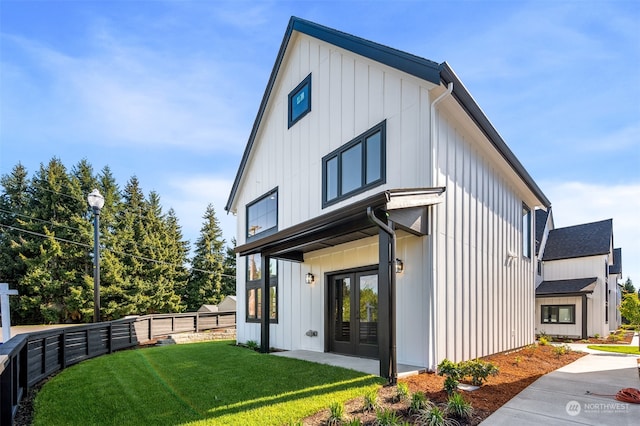 back of property with french doors and a lawn