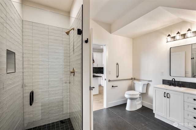 bathroom with tile patterned flooring, backsplash, vanity, a tile shower, and toilet