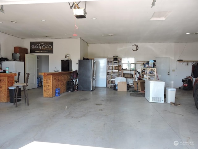 1402 Adams Rd N, Quincy, WA 98848 - garage with a garage door opener, freestanding refrigerator, and fridge