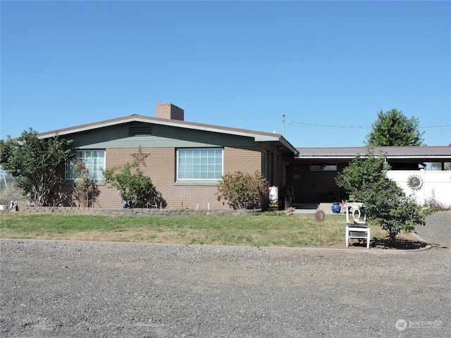1402 Adams Rd N, Quincy, WA 98848 - view of front of house with brick siding, an attached carport, and a chimney