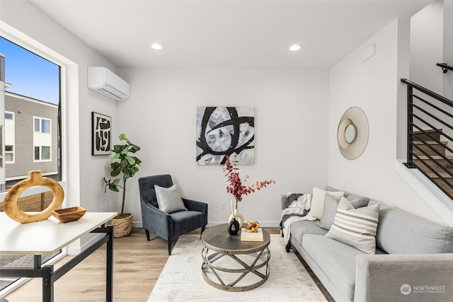 living room featuring a wall unit AC and light hardwood / wood-style flooring