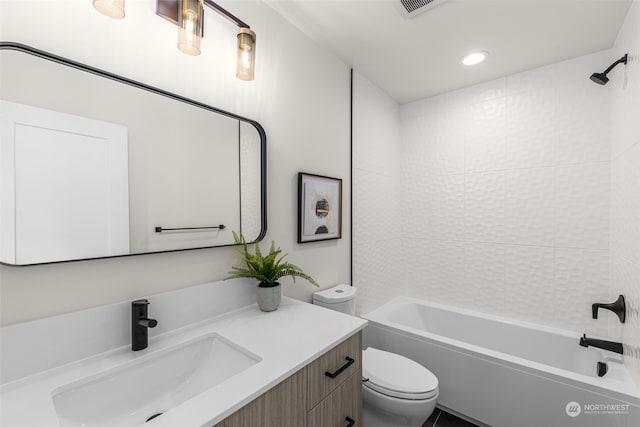 full bathroom with vanity, tiled shower / bath combo, and toilet