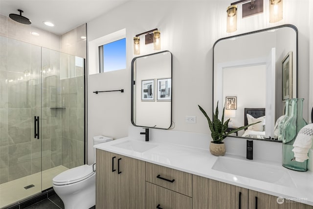 bathroom with tile patterned floors, vanity, a shower with shower door, and toilet