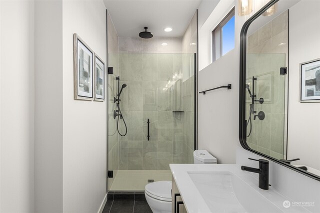 bathroom featuring tile patterned floors, vanity, toilet, and a shower with shower door