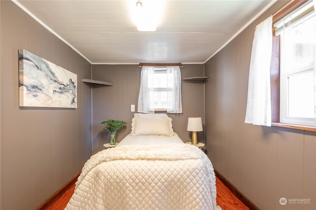 bedroom with multiple windows, dark wood-type flooring, and crown molding