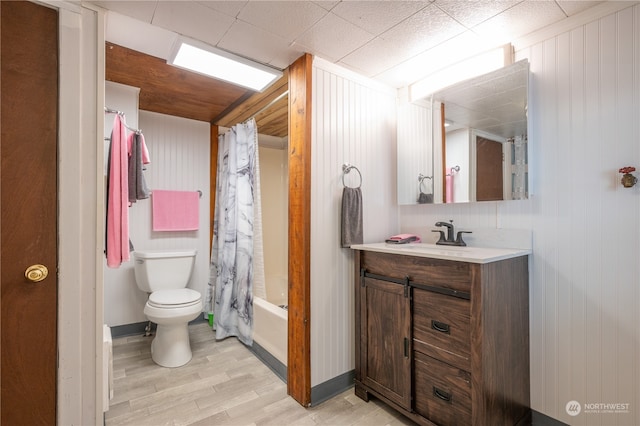 full bathroom with shower / bath combination with curtain, large vanity, hardwood / wood-style floors, and toilet