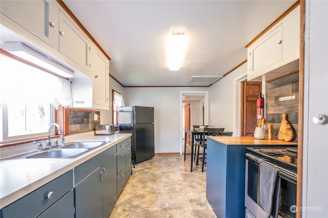 kitchen with range with electric cooktop, black refrigerator, white cabinetry, and sink