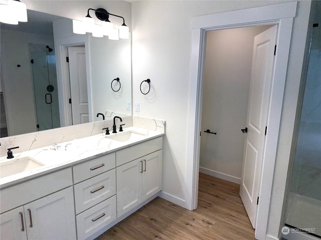 bathroom featuring hardwood / wood-style floors, vanity, and a shower with shower door