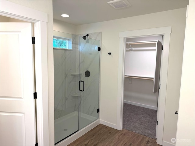 bathroom with wood-type flooring and a shower with shower door