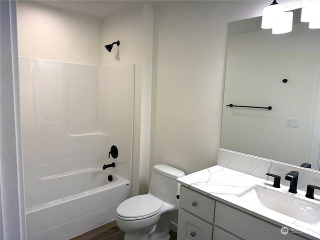 full bathroom featuring hardwood / wood-style floors, vanity, shower / bathtub combination, and toilet