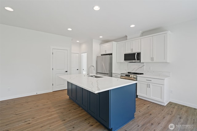 11114 NE 91st Ave, Vancouver, WA 98662 - kitchen with white cabinets, a sink, stainless steel appliances, baseboards, and a kitchen island with sink