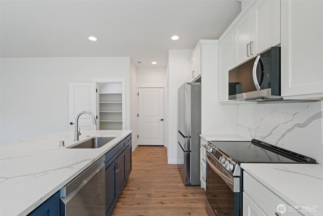11114 NE 91st Ave, Vancouver, WA 98662 - kitchen with a sink, stainless steel appliances, light wood-type flooring, white cabinets, and blue cabinets