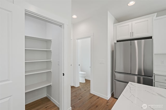 11114 NE 91st Ave, Vancouver, WA 98662 - kitchen featuring recessed lighting, light wood-style flooring, light stone counters, freestanding refrigerator, and white cabinetry