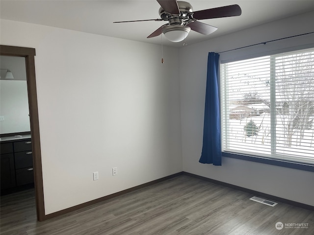 empty room with ceiling fan and dark wood-type flooring