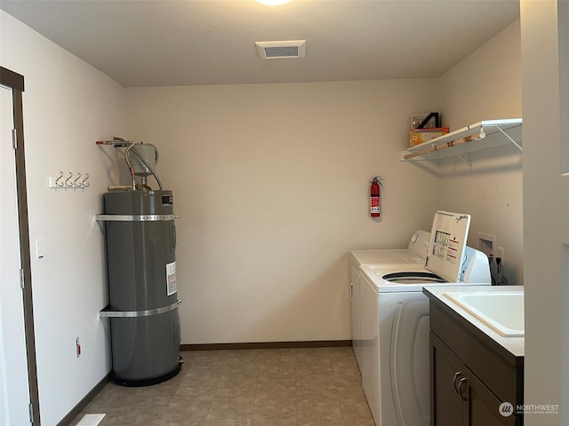 washroom featuring water heater, washer hookup, washing machine and clothes dryer, light tile floors, and cabinets