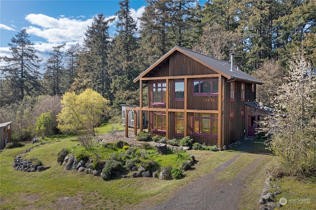 rear view of house featuring a yard