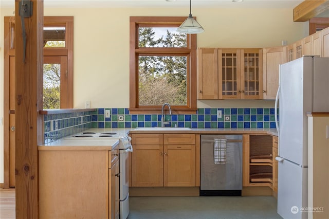 kitchen featuring a healthy amount of sunlight, hanging light fixtures, white appliances, and sink