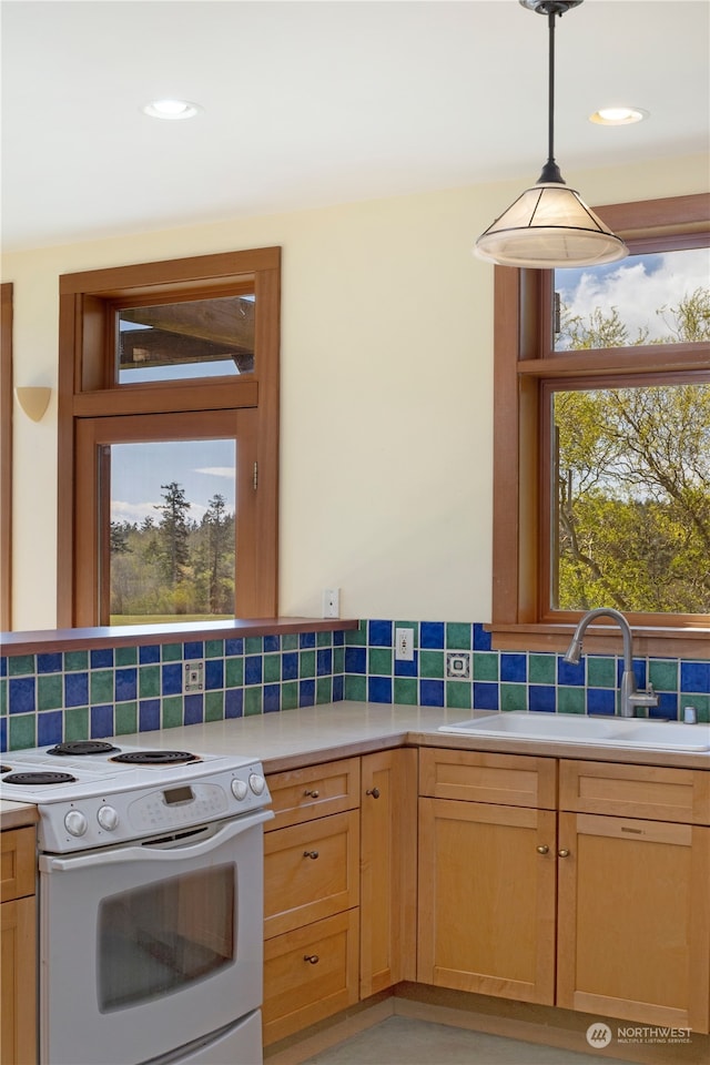 kitchen featuring backsplash, pendant lighting, a wealth of natural light, and white electric range oven