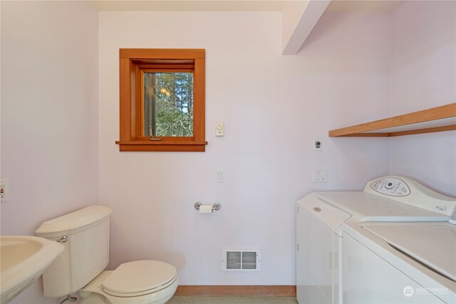 clothes washing area with sink and washer and dryer